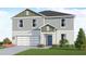 Two-story house with green and gray siding, two-car garage, and landscaping at 4523 Boxelder Avenue, Parrish, FL 34219