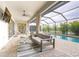 Covered patio with seating and pool overlooking lake at 4814 Sparkling Sea Ln, Lakewood Ranch, FL 34211