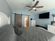 Bright bedroom with a barn door, ceiling fan, and large TV at 5303 14Th Avenue W Dr, Bradenton, FL 34209