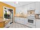 Bright kitchen featuring white cabinetry and a breakfast bar at 5343 Huntingwood Ct # 33, Sarasota, FL 34235