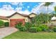 Single-story home with landscaped yard and two-car garage at 5931 Caspian Tern Dr, Sarasota, FL 34238