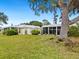 Backyard with spacious grassy area, partially visible patio, and large tree at 5940 Driftwood Ave # 15, Sarasota, FL 34231