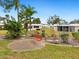 Landscaped community garden with a park bench, lush tropical plants, and gravel at 5940 Driftwood Ave # 15, Sarasota, FL 34231