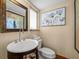 Stylish bathroom with a pedestal sink, toilet, and framed wall art at 600/602 Beach Rd # 1 & 2, Sarasota, FL 34242