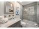 Bathroom with tub and shower, marble vanity, and grey tile at 600/602 Beach Rd # 1 & 2, Sarasota, FL 34242