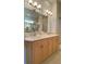 Bathroom with dual sinks and light wood cabinets at 636 Lakescene Drive Dr, Venice, FL 34293