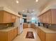 Galley kitchen with light wood cabinets and white appliances at 636 Lakescene Drive Dr, Venice, FL 34293