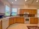 L-shaped kitchen with light wood cabinets and corner sink at 636 Lakescene Drive Dr, Venice, FL 34293