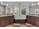 Elegant bathroom with a corner soaking tub, double vanity, and checkered flooring at 7817 Passionflower Dr, Sarasota, FL 34241