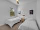 Twin bedroom with two beds, nightstand, and window at 7817 Passionflower Dr, Sarasota, FL 34241