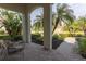 Relaxing covered patio with brick pavers, comfortable seating, and tranquil garden views at 7817 Passionflower Dr, Sarasota, FL 34241