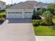 Exterior of a single-Gathering home with a three-car garage and landscaped yard at 7817 Passionflower Dr, Sarasota, FL 34241