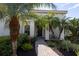 Inviting front entry with a brick walkway, lush landscaping, and a charming covered porch at 7817 Passionflower Dr, Sarasota, FL 34241