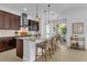 Modern kitchen with dark wood cabinets, granite countertops, and an island with seating at 7817 Passionflower Dr, Sarasota, FL 34241