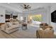 Spacious living room features a sectional sofa, large TV, and views of the pool area at 7817 Passionflower Dr, Sarasota, FL 34241