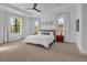 Spacious main bedroom with a large bed, ceiling fan, and ample natural light at 7817 Passionflower Dr, Sarasota, FL 34241