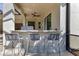 Poolside bar with granite countertop and three gray stools at 7817 Passionflower Dr, Sarasota, FL 34241