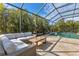 Covered patio with sectional sofa and coffee table, overlooking the pool at 7817 Passionflower Dr, Sarasota, FL 34241