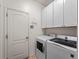 Clean laundry room with white cabinets and modern washer/dryer set at 8107 High Oaks Trl, Myakka City, FL 34251