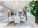 Elegant dining area with a marble table, white chairs, and large window at 8635 Ocean Tides Cv, Parrish, FL 34219