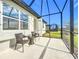 Relaxing screened porch with wicker chairs overlooking the backyard at 8635 Ocean Tides Cv, Parrish, FL 34219