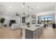 Open concept kitchen with island, stainless steel appliances, and living room view at 9020 Artisan Way, Sarasota, FL 34240