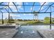 Inviting pool and spa area with a screened enclosure and lake view at 9020 Artisan Way, Sarasota, FL 34240