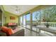 Bright sunroom features a ceiling fan and access to a private balcony with nature views at 919 Waterside Ln, Bradenton, FL 34209