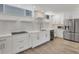 Spacious kitchen boasts white cabinetry, stainless steel appliances, and a breakfast bar at 100 Sands Point Rd # 323, Longboat Key, FL 34228