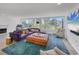 Bright living room with large windows, stylish furniture, and hardwood floors at 100 Sands Point Rd # 323, Longboat Key, FL 34228