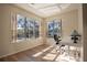 Bright home office features large windows, a comfortable desk chair, and hardwood floors at 1178 Fraser Pine Blvd, Sarasota, FL 34240