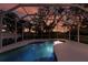 Pool at sunset with colorful sky reflected in water at 1178 Fraser Pine Blvd, Sarasota, FL 34240