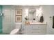 Modern bathroom with a glass shower, white vanity and a teal tile accent wall at 1211 Gulf Of Mexico Dr # 603, Longboat Key, FL 34228