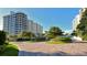 Luxury condominium building with manicured landscaping and paved pathways at 1211 Gulf Of Mexico Dr # 603, Longboat Key, FL 34228