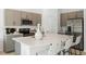 Modern kitchen with gray cabinets, quartz countertops, and stainless steel appliances at 15048 Cuzcorro Ct, Nokomis, FL 34275