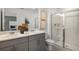 Bathroom with double vanity, a large mirror and a glass-enclosed shower at 15052 Cuzcorro Ct, Nokomis, FL 34275