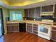 Kitchen features wood cabinets, white appliances, and laminate floors at 1627 Baywinds Ln, Sarasota, FL 34231