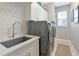 Modern laundry room with a utility sink and washer/dryer at 16806 5Th Ne Ter, Bradenton, FL 34212