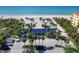 Aerial view of the beach access building with parking, palm trees, and access to the beach and blue ocean waters at 1906 Harbour Links Cir # 14, Longboat Key, FL 34228