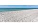 Expansive white sand beach meets tranquil turquoise waters under a clear blue sky at 1906 Harbour Links Cir # 14, Longboat Key, FL 34228