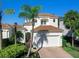 Two-story home with tile roof, white exterior, and lush landscaping at 1906 Harbour Links Cir # 14, Longboat Key, FL 34228