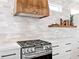 Modern kitchen with wood range hood and white cabinets at 1906 Harbour Links Cir # 14, Longboat Key, FL 34228