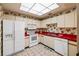 Bright kitchen featuring white appliances and red countertops at 204 3Rd W St # 203, Bradenton, FL 34205