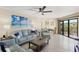 Comfortable living room featuring light sofas, a ceiling fan, and balcony access at 204 3Rd W St # 203, Bradenton, FL 34205