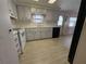 View of a galley kitchen with white appliances and light wood cabinets at 2107 Palma Sola Blvd # 27, Bradenton, FL 34209