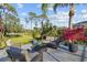Peaceful back patio with wicker furniture and lush tropical landscaping at 2305 Little Country Rd, Parrish, FL 34219