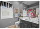 Clean bathroom with dark vanity, shower, and patterned curtain at 2305 Little Country Rd, Parrish, FL 34219