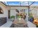Covered patio with wood table and wicker chairs at 2305 Little Country Rd, Parrish, FL 34219