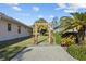 Landscaped side yard with a charming pergola and brick pathway at 2305 Little Country Rd, Parrish, FL 34219