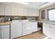 Laundry room with white cabinets, washer, dryer, and utility sink at 2912 Bayshore Gardens Pkwy, Bradenton, FL 34207